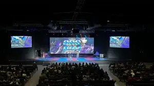 Contemporary church sanctuary, interior, wide view of a contemporary church service with church audio visual equipment including several loudspeakers, a large LED video wall, two projector screens, and lots of truss and LED stage lights on display
